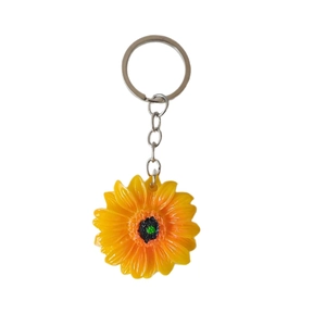 Portachiavi girasole vibrante con petali gialli e anello in metallo su sfondo bianco