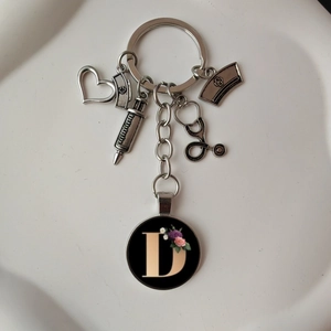 Detail of medical keychain with stethoscope and initial D on a white background