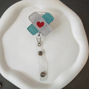 Close-up of heart patterned bandage style retractable badge holder with metal clip