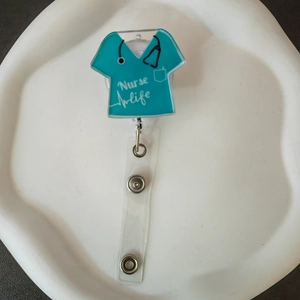 Detail showing retractable nurse life badge holder with acrylic blue scrub design