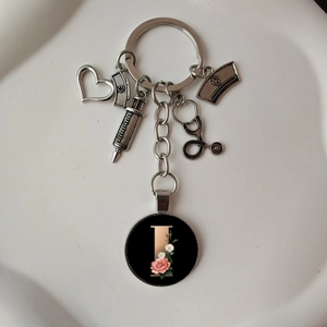 Detailed close-up of stethoscope keychain with heart and floral letter I charm