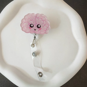 Close-up of cute acrylic brain badge reel with pink details for nurse and doctor ID cards