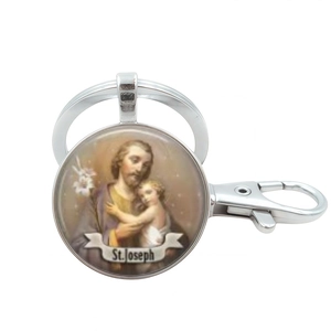 Close-up of Saint Joseph religious glass pendant keychain with silver metal clip