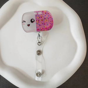 Detail of retractable acrylic badge reel with cartoon capsule design and PVC strap