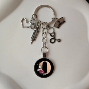 Detailed view of silver medical keychain with stethoscope and floral letter D pendant