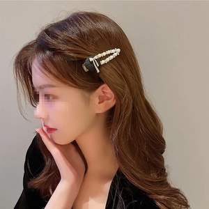 Pince à cheveux vintage avec nœud noir, perles et strass portée par un mannequin