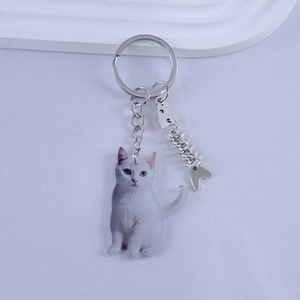 Detailed close-up of a resin cat keychain with a silver fishbone charm and metal ring