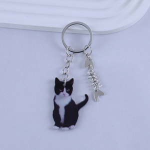 Detail of cartoon resin cat keychain with fishbone charm and silver key ring attachment