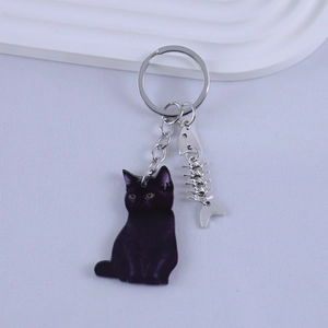 Detailed view of a black resin cat keychain with a silver metal fishbone charm and link chain