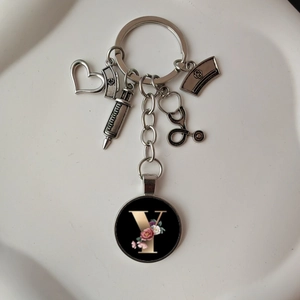 Detailed view of silver medical keychain with heart, stethoscope and floral letter Y charm