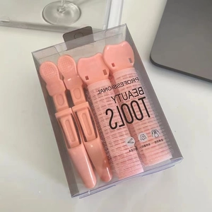 Dettaglio di clip rosa per radici dei capelli e rulli in una scatola di bellezza trasparente