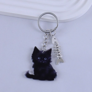 Detail of cartoon black cat keychain with acrylic finish and silver fish bone charm
