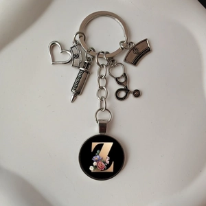 Macro view of stethoscope heart keychain with floral letter Z charm on white background
