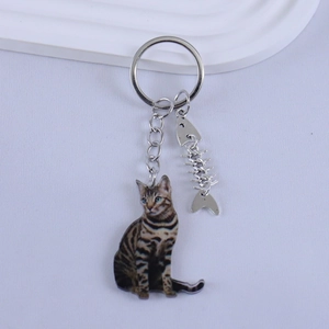 Detail of cute tabby cat resin keychain with silver fishbone charm on a clean background