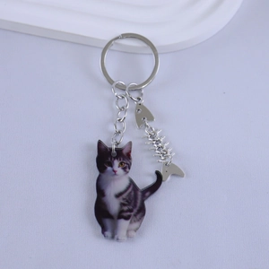 Close-up of realistic grey tabby cat resin keychain with a silver fish bone charm