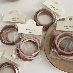 Detail of high-elastic hair ties in earth tones with matching beads and card packaging