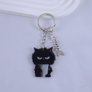 Close-up of black resin cat keychain with coffee cup and small metal fishbone charm