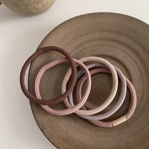 Set of 5 high elasticity hair ties in earth-toned colors on a ceramic tray for women