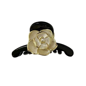 Elegant black hair claw clip with white camellia flower and pearl accent on white background