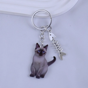 Detail view of Siamese cat acrylic keychain featuring a cute silver fishbone pendant