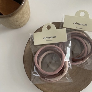 Close-up of Morandi warm brown elastic hair bands in transparent packaging with card