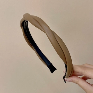 Detail shot of the twisted light brown faux leather headband showing fine texture and lining