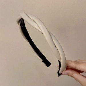 Detailed close-up of cream twisted knot headband with elegant faux leather texture