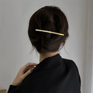 Minimalistische goldene Metall-Haarklammer für Damen in einer eleganten Hochsteckfrisur