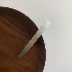 Detailed view of the minimalist silver metal hair clip featuring a matte brushed texture