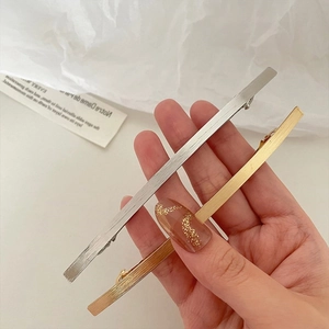 Detaillierte Nahaufnahme goldener und silberner Metall-Haarspangen mit gebürsteter Textur