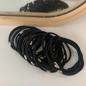 Set of high-elastic black hair ties with gold decorative buckles on a white surface