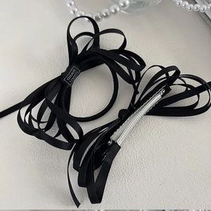 Detail of handmade black silk ribbon bow hair clip with silver metal alligator clip mechanism