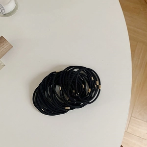 Set of high-elastic black hair ties with elegant gold metal buckles on a white surface