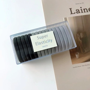 Close-up of seamless gradient grey elastic hair ties in a clear storage box