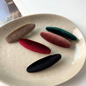 Five vintage velvet duckbill hair clips in deep autumn colors on a ceramic tray