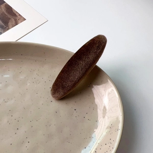 French vintage brown velvet duckbill hair clip on a ceramic plate with white background