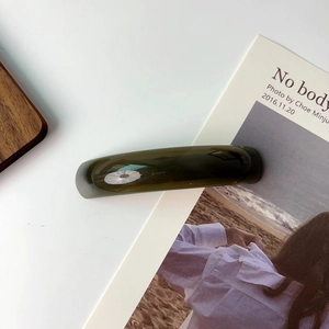 Elegant translucent dark green acetate curved hair clip in a minimalist French vintage style
