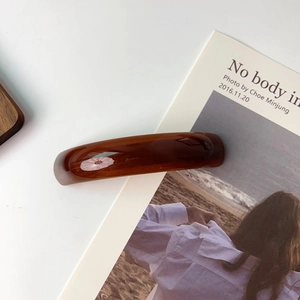 Close-up of elegant dark brown amber acetate hair clip with premium glossy finish
