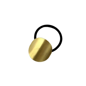 Minimalist elastic hair tie with round golden brushed metal plate on white background