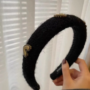 Detail of black plush padded headband with vintage metal heart accents and handmade label