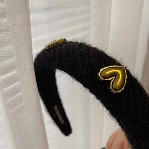 Padded black plush headband with gold heart metal charms and soft knitted texture