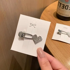 Elegant heart-shaped rhinestone hair clip with silver-tone finish on display card