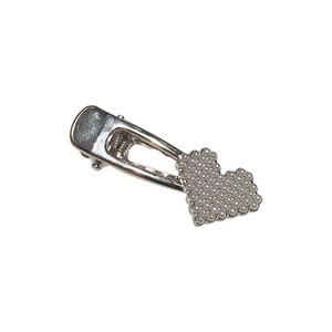 Detailed close-up of heart-shaped pearl hair clip with silver-tone metal duckbill base