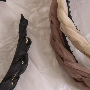 Drei geflochtene Haarreifen in Schwarz, Braun und Beige mit feinen goldenen Kettendetails