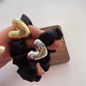 Elegant black scrunchie with metallic heart detail in gold and silver finish