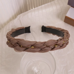 Detail eines handgewebten Chiffon-Stirnbands mit Goldperlen und Metallketten