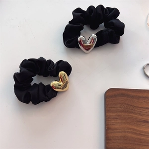 Detail of black fabric hair scrunchies with gold and silver LOVEDAYS heart pendants
