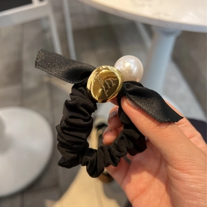 Chouchou en soie noire avec nœud, grande perle blanche et détail en métal doré élégant