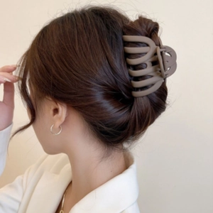 Brown matte claw clip holding hair in an elegant updo, side view on female model