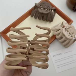 Large matte brown and cream claw clips in a stylish trio for elegant hair styling